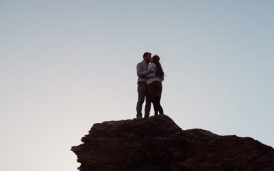Photo d'un couple qui s'embrasse en haut d'une montagne